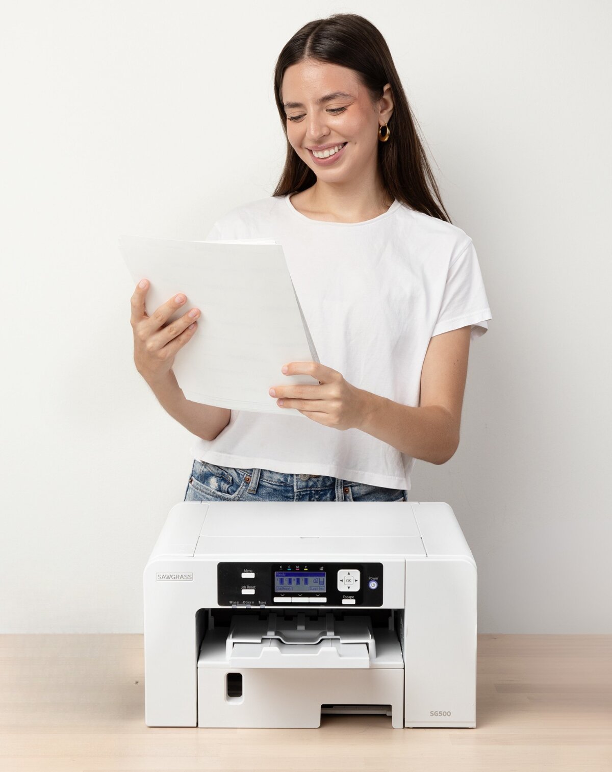 Creator holding transfer paper behind a Sawgrass VersiFlex printer