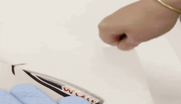 Peeling VersiFlex Light transfer paper from a printed garment